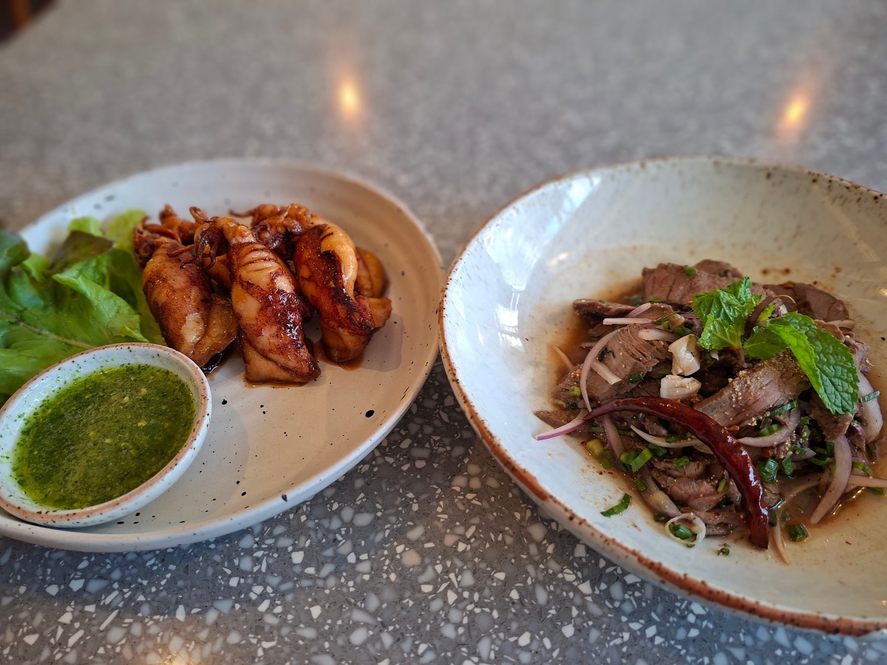 Deep-fried squid and grilled beef spicy salad served side by side at Lay Lao